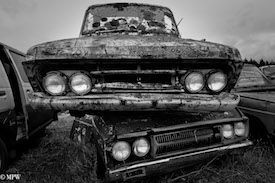 A series of photos taken using the headlamps of wrecked cars as the focus point.