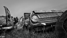 A series of photos taken using the headlamps of wrecked cars as the focus point.